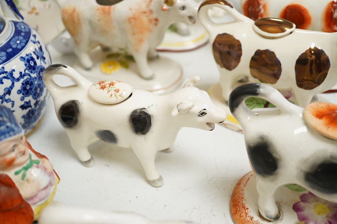 A large collection of English pottery cow creamers, Staffordshire figures and cruets a blue and white teapot and sponge ware dish-34cm diameter, (26)